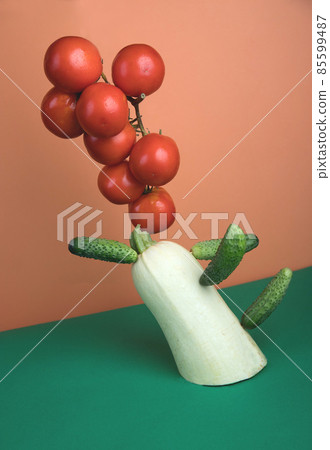 Vegetable levitation with zucchini, cucumbers and a tomato branch on a colored paper background. Vegetable levitation with zucchini, cucumbers and a tomato branch on a colored paper background. 85599487