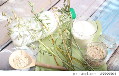 An alternative to animal milk is oat milk on a light table . Vegan product An alternative to animal milk is oat milk on a light table . Vegan product 85599504