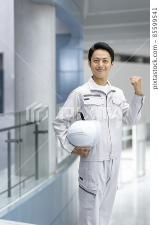 A portrait of a man in work clothes looking at the camera and smiling 85599541