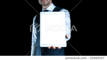 Device mockups. Businessman holding mobile tablet blank screen. Smart technology device mock up isolated on black banner background. Mockup for application or website design project. 85600567