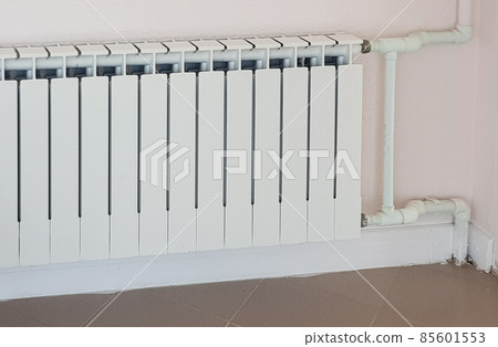 Modern aluminum white heating radiator on the background of a wall in a residential area Modern aluminum white heating radiator on the background of a wall in a residential area 85601553