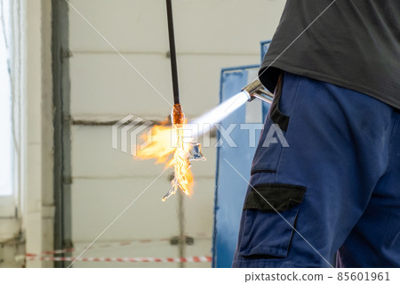 A man uses a gas burner to melt glass. A craftsman makes a glass in a leaf shaped. A man uses a gas burner to melt glass. A craftsman makes a glass in a leaf shaped. 85601961