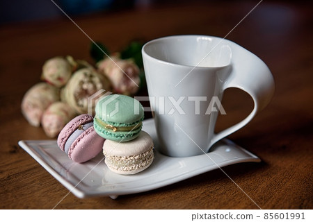 Macaron and cup of coffee on wooden background. Macaron and cup of coffee on wooden background. 85601991