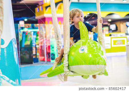 Young boy thrilled on the carousel ride 85602417