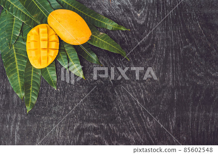 Mango and mango leaves on an old wooden background 85602548