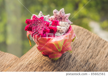 Pieces of sliced dragon fruit in the form of a star on an old withered background Pieces of sliced dragon fruit in the form of a star on an old withered background 85602561