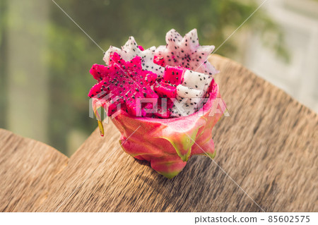 Pieces of sliced dragon fruit in the form of a star on an old withered background Pieces of sliced dragon fruit in the form of a star on an old withered background 85602575