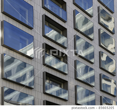 reflections in the mirrored windows of a modern building 85603205