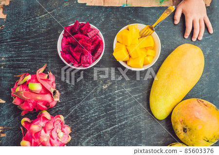 Little cute boy eating mango on the terrace 85603376