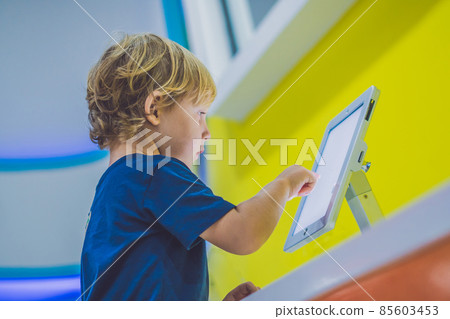 Boy playing with digital tablet. Children and technology concept Boy playing with digital tablet. Children and technology concept 85603453