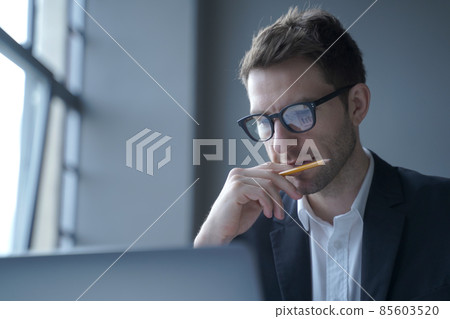 Serious german man executive dressed in formal clothes looking at laptop screen browsing internet Serious german man executive dressed in formal clothes looking at laptop screen browsing internet 85603520