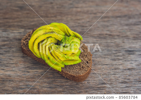 Avocado sandwich on dark rye bread made with fresh sliced avocados 85603784