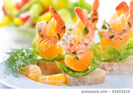 Scampi skewers with mandarin on Italian bread 85603828