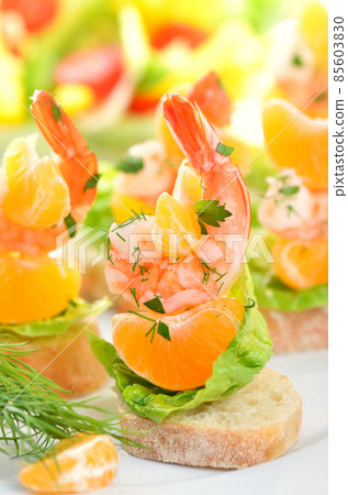 Scampi skewers with mandarin on Italian bread 85603830