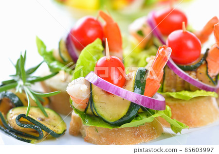 Scampi skewers with fried zucchini on Italian bread 85603997