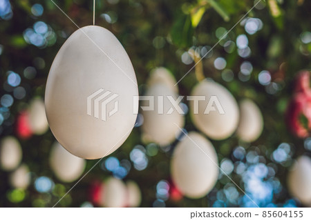 Easter eggs hang on ropes on a tree. Easter eggs hang on ropes on a tree. 85604155