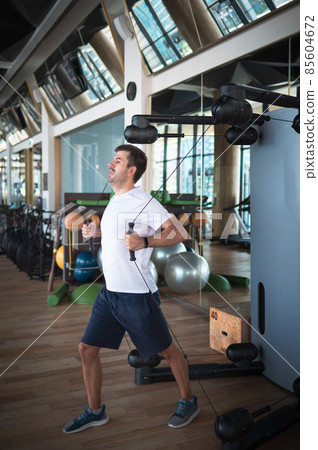 Man exercising in the gym on a pec deck machine for chest workout 85604672