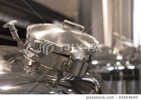 Modern Beer Factory. Steel tanks for beer fermentation and storage. Brewery. Modern beer plant with brewering kettles Modern Beer Factory. Steel tanks for beer fermentation and storage. Brewery. Modern beer plant with brewering kettles 85604689