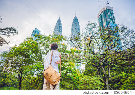 Man tourist in Malaysia looks at the Petronas Twin Towers Man tourist in Malaysia looks at the Petronas Twin Towers 85604694