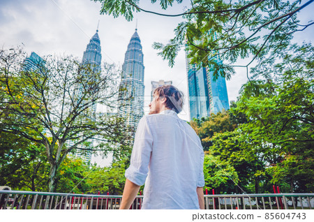 Man tourist in Malaysia looks at the Petronas Twin Towers Man tourist in Malaysia looks at the Petronas Twin Towers 85604743