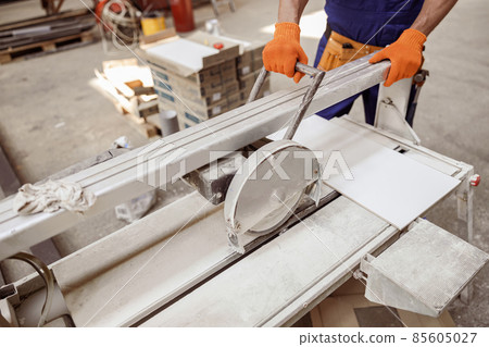 Male worker using sawing machine in workshop 85605027