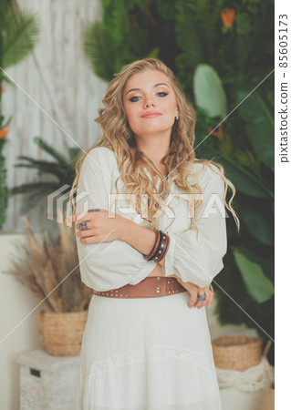 Glamorous woman with blonde curly hair smiling and resting in tropical resort 85605173