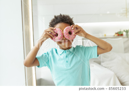 Happy little boy with tasty donuts on white background Happy little boy with tasty donuts on white background 85605233