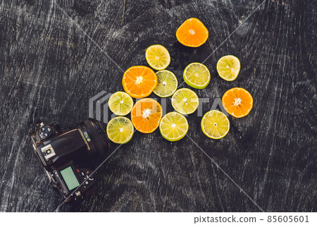 Camera and mixed fruits: ranges, lemons on wooden board 85605601