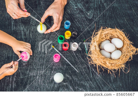 Happy easter A mother, father and their son painting Easter eggs. Happy family preparing for Easter 85605667