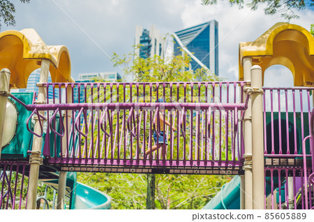 Happy little kid boy playing at colorful playground. Adorable child having fun outdoors 85605889