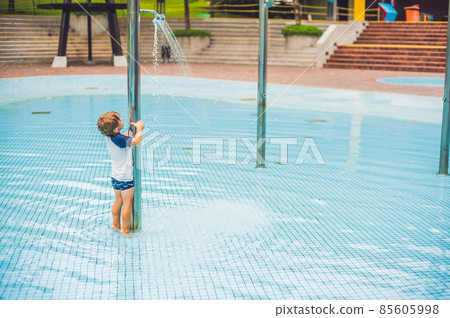 Boy playing in the paddling pool in the summertime Boy playing in the paddling pool in the summertime 85605998