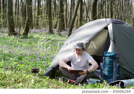 Traveller uses a tablet outdoors. 85606284