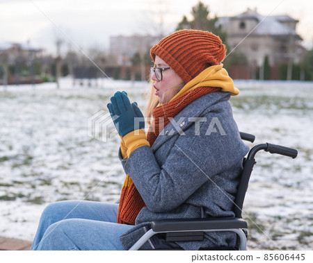Caucasian woman freezes in a wheelchair in winter. 85606445