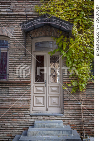 Old vintage wooden doors in old Tbilisi. Facades of stone houses. Old vintage wooden doors in old Tbilisi. Facades of stone houses. 85607087