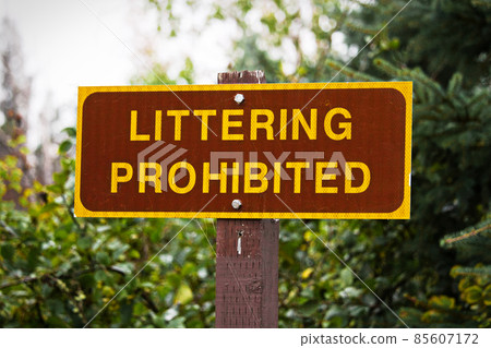 A Littering Prohibited sign with trees in the background 85607172