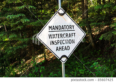 A white mandatory watercraft inspection ahead sign 85607425