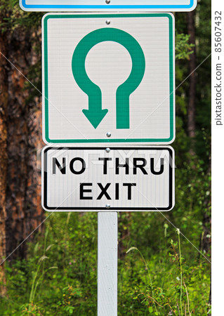 A no thru exit sign with trees in the background 85607432