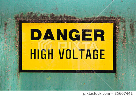 A danger high voltage sign on a green background A danger high voltage sign on a green background 85607441