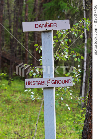 A danger, unstable ground sign along a hiking trail 85607456