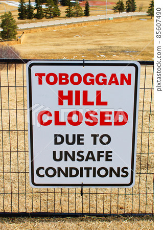 Toboggan hill closed sign posted in a public park once all the snow has melted 85607490