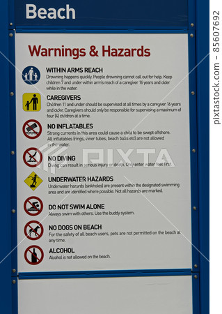 A beach warning and hazards sign with regulations 85607692