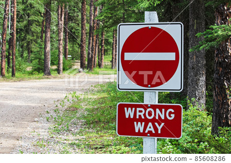 A do not enter, wrong way sign beside a gravel road 85608286