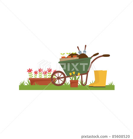 Spring landscape in the garden with green grass, flower, garden wheelbarrow, shovel. Spring landscape in the garden with green grass, flower, garden wheelbarrow, shovel. 85608520