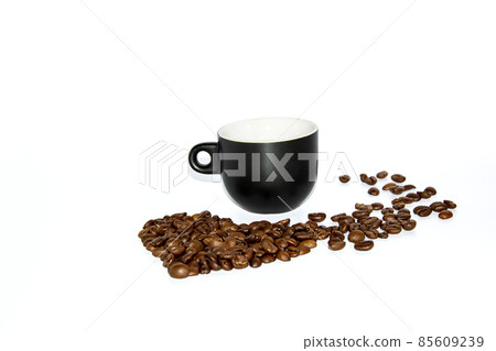 Small black heart shaped coffee cup with scattered beans on a white background. Front view. Isolate. Lifestyle. Small black heart shaped coffee cup with scattered beans on a white background. Front view. Isolate. Lifestyle. 85609239