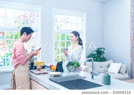 一個家庭主婦看著一個做飯的丈夫 85609316