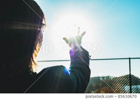 High school girl holding her hand over the sun 85610670