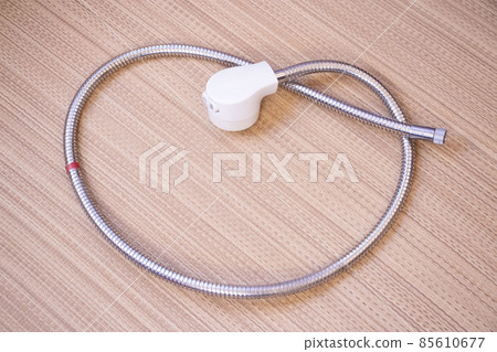 日本淋浴軟管零件、頭部和金屬軟管放在榻榻米墊上 85610677