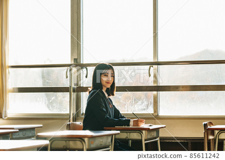 High school girl illuminated by the setting sun after school 85611242