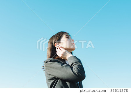 High school girl listening to music with earphones High school girl listening to music with earphones 85611278