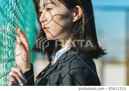 High school girl standing in front of the fence 85611313